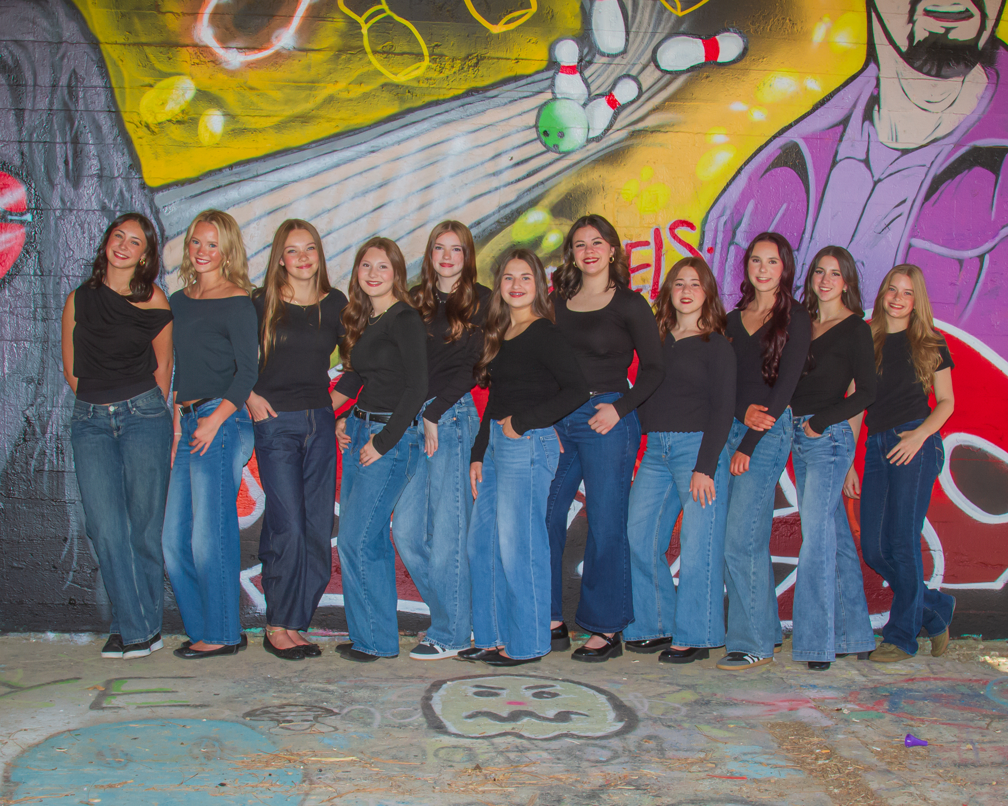 SODC dancers standing together in front of a colorful graffiti wall