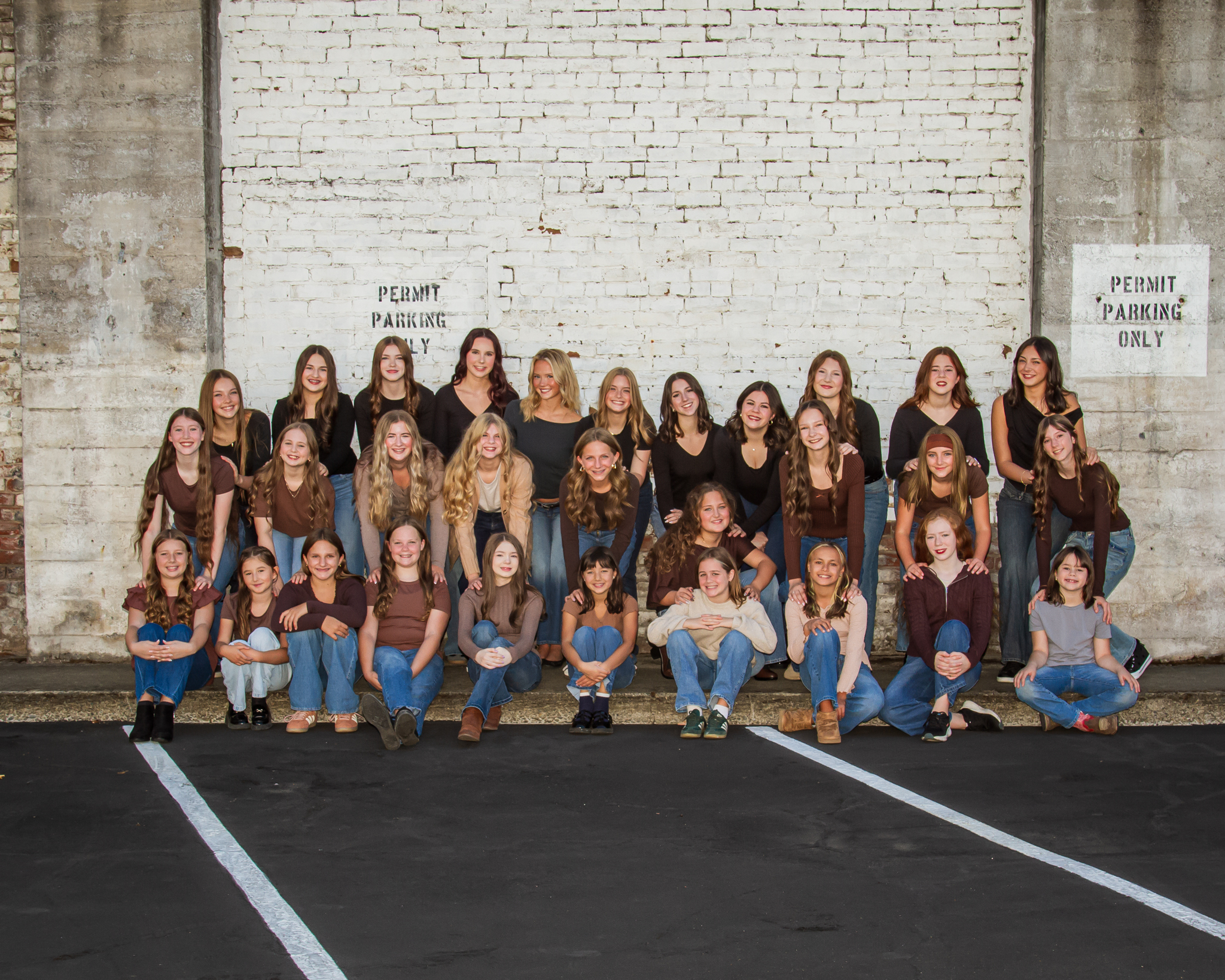 Large group of SODC dancers posing together against a brick wall