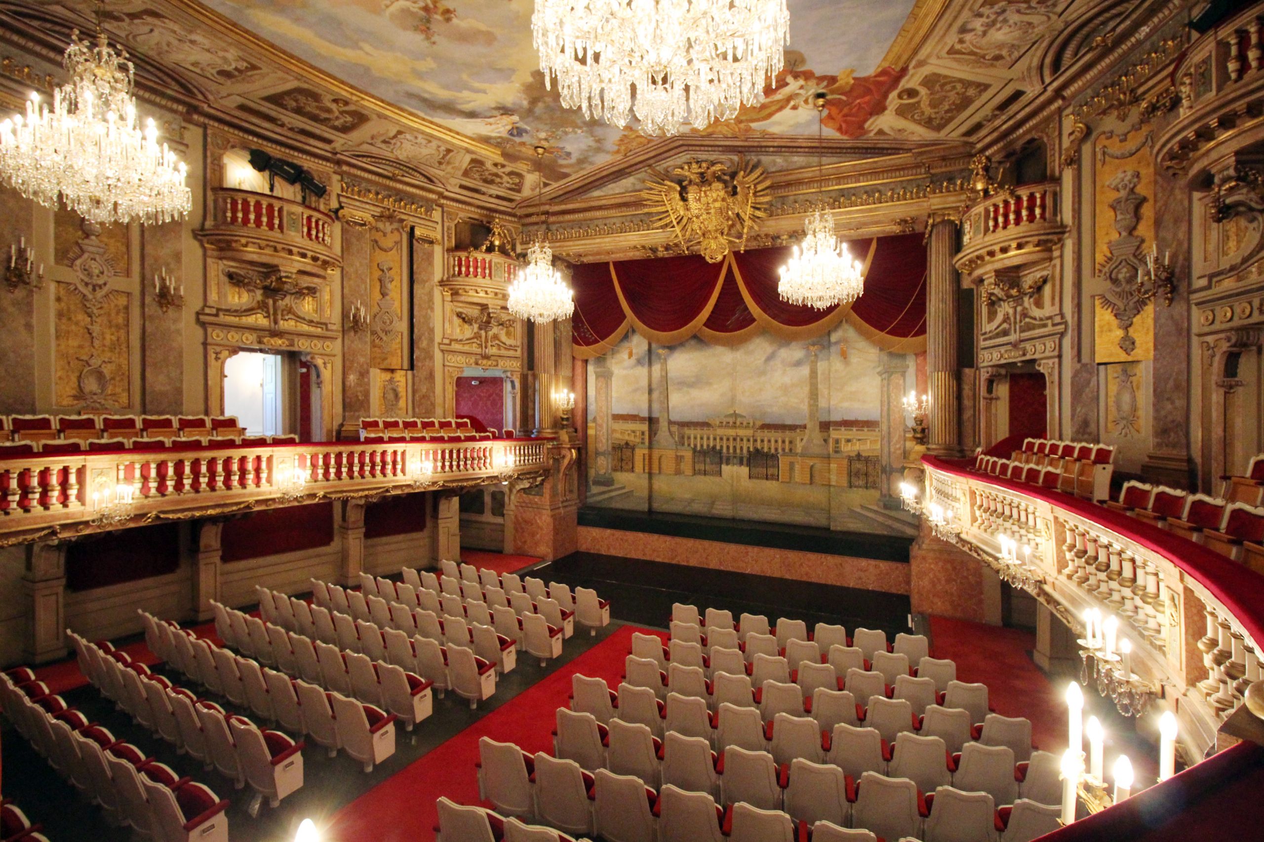 Ornate theatre interior with chandeliers, balconies and rows of seats