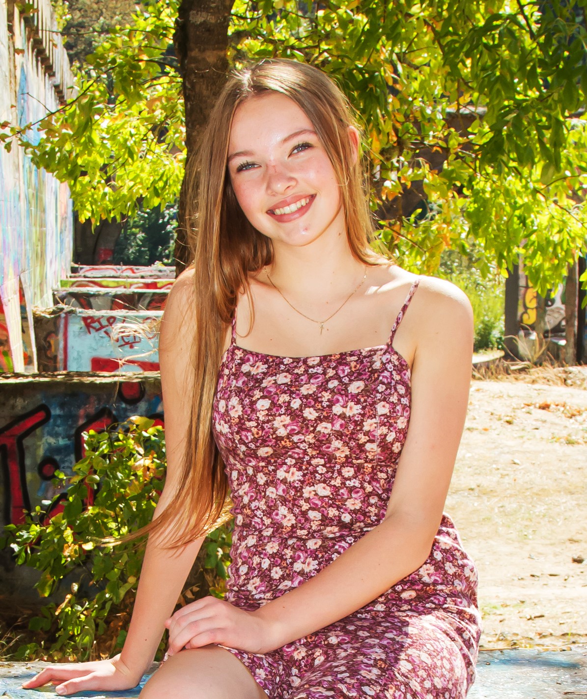Katie seated outdoors in a floral dress